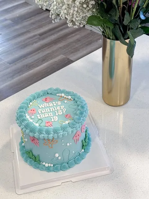 Aqua cake with piped borders, pink jellyfish and birthday lettering
