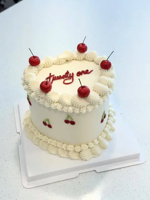 Cream cake with red cherries, red lettering and piped borders