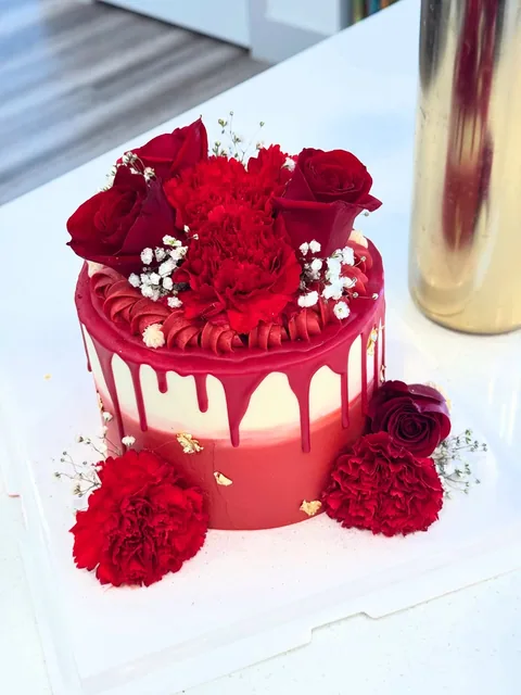 Red drip cake with red roses and other red flowers