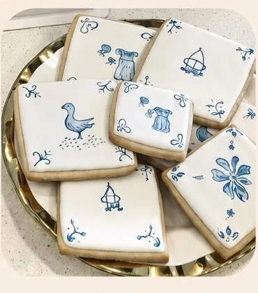 White sugar cookies decorated with simple blue illustrations