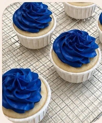 Vanilla cupcakes topped with deep blue piped frosting