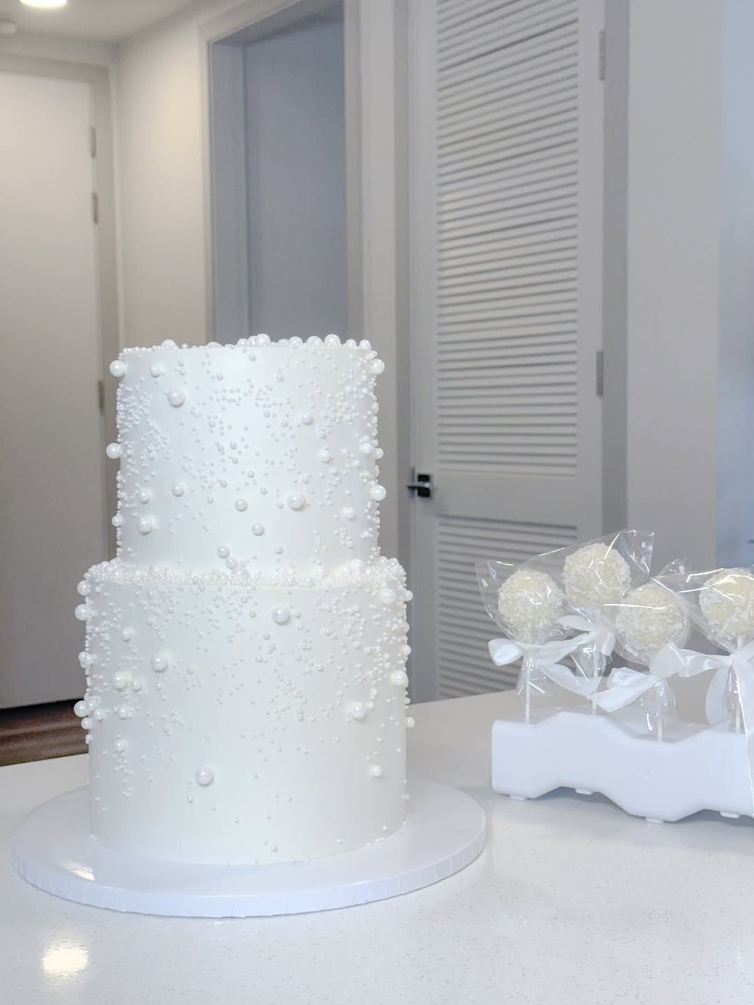 Nicka’s white two-tier cake decorated with delicate pearls